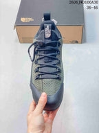 Front view showing the lace-up closure and green-gray patterned upper.