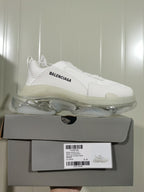 White Balenciaga Triple S sneaker displayed on its box; the box label shows Triple S Clear Sole, all white, and EU size 41.
