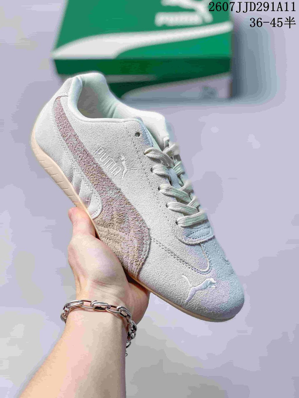 Pale grey PUMA Speedcat-style sneaker with a textured upper, multicolor side stripe, and gum-colored outsole.