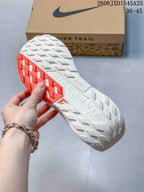 Close-up of the trail-style outsole with white and red tread