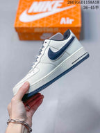 Side view of the white and navy low-top sneaker showing the contrasting Swoosh, layered panels, and textured outsole.