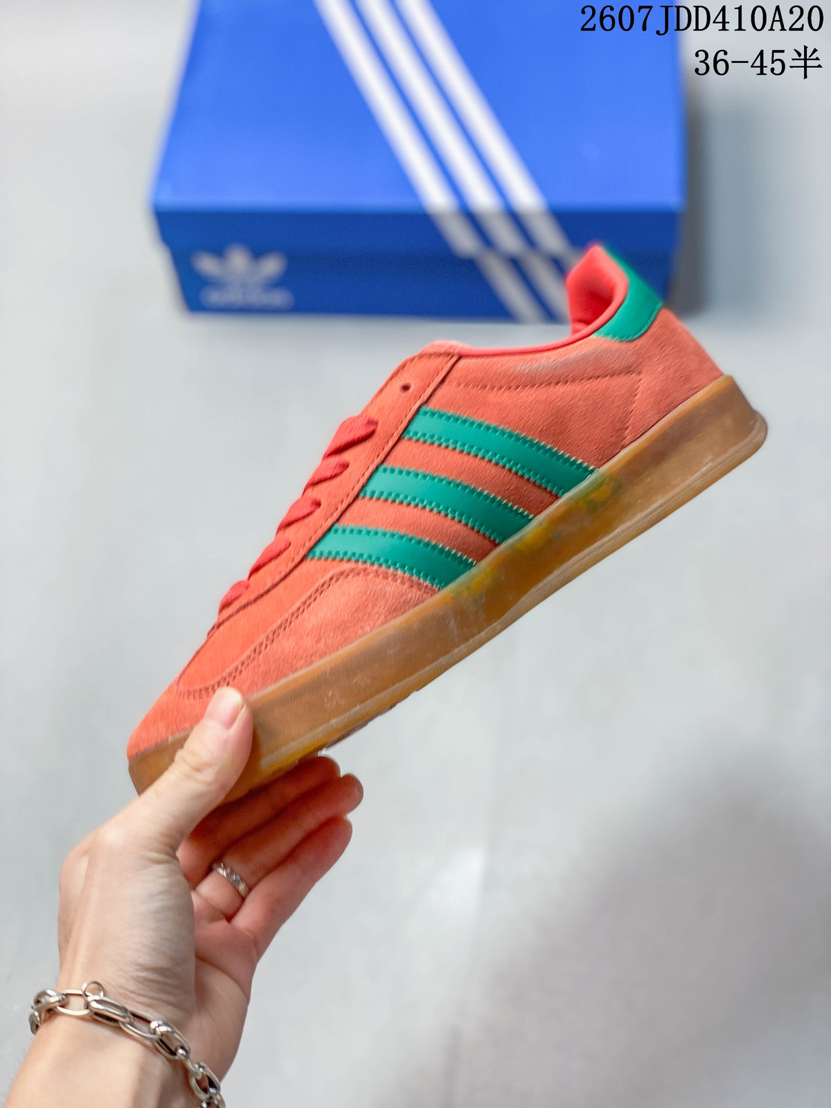 Side profile showing the coral upper, green side stripes, green heel tab and gum-colored outsole.