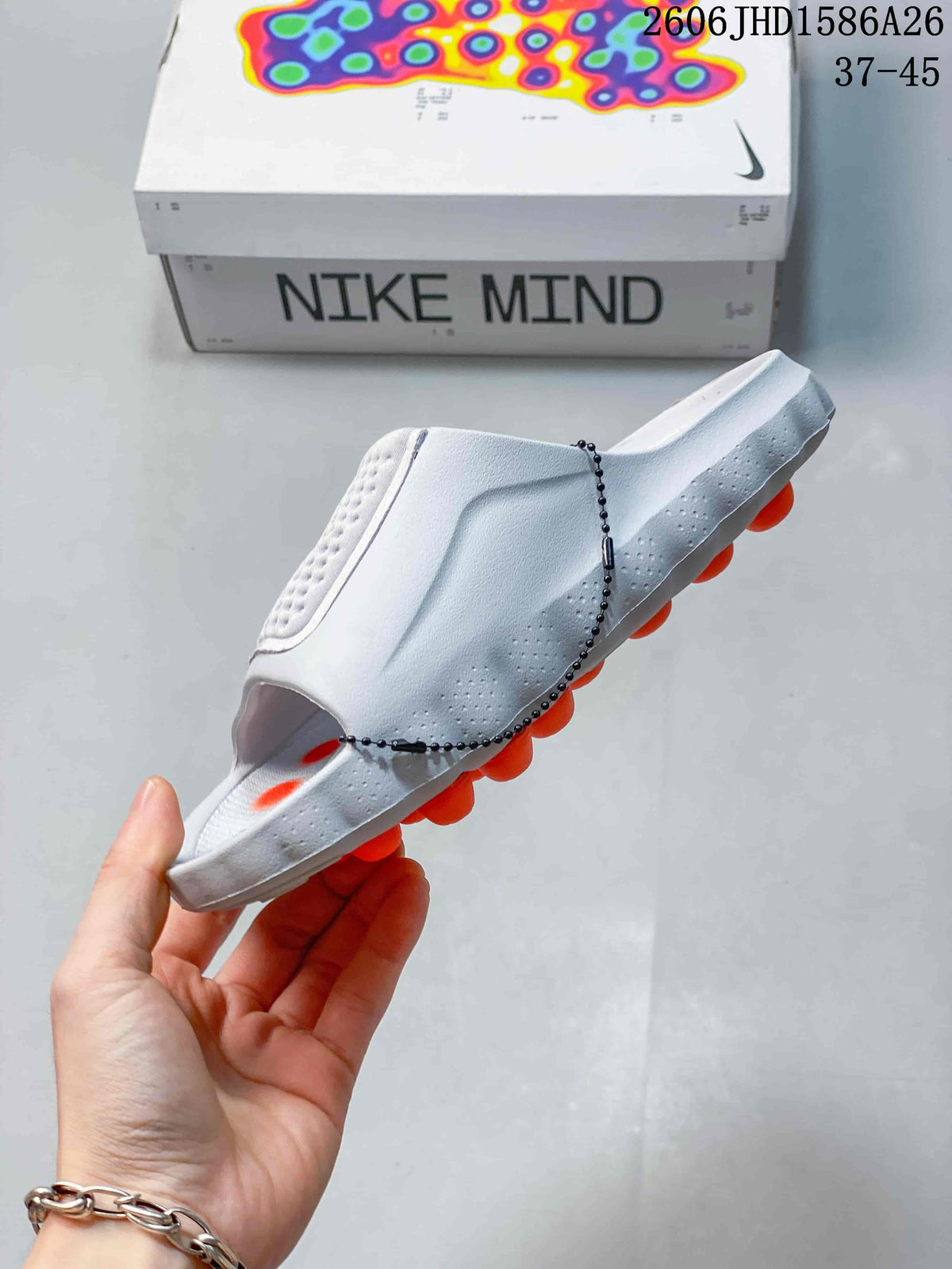 Side view of the white slide sandal with orange outsole elements