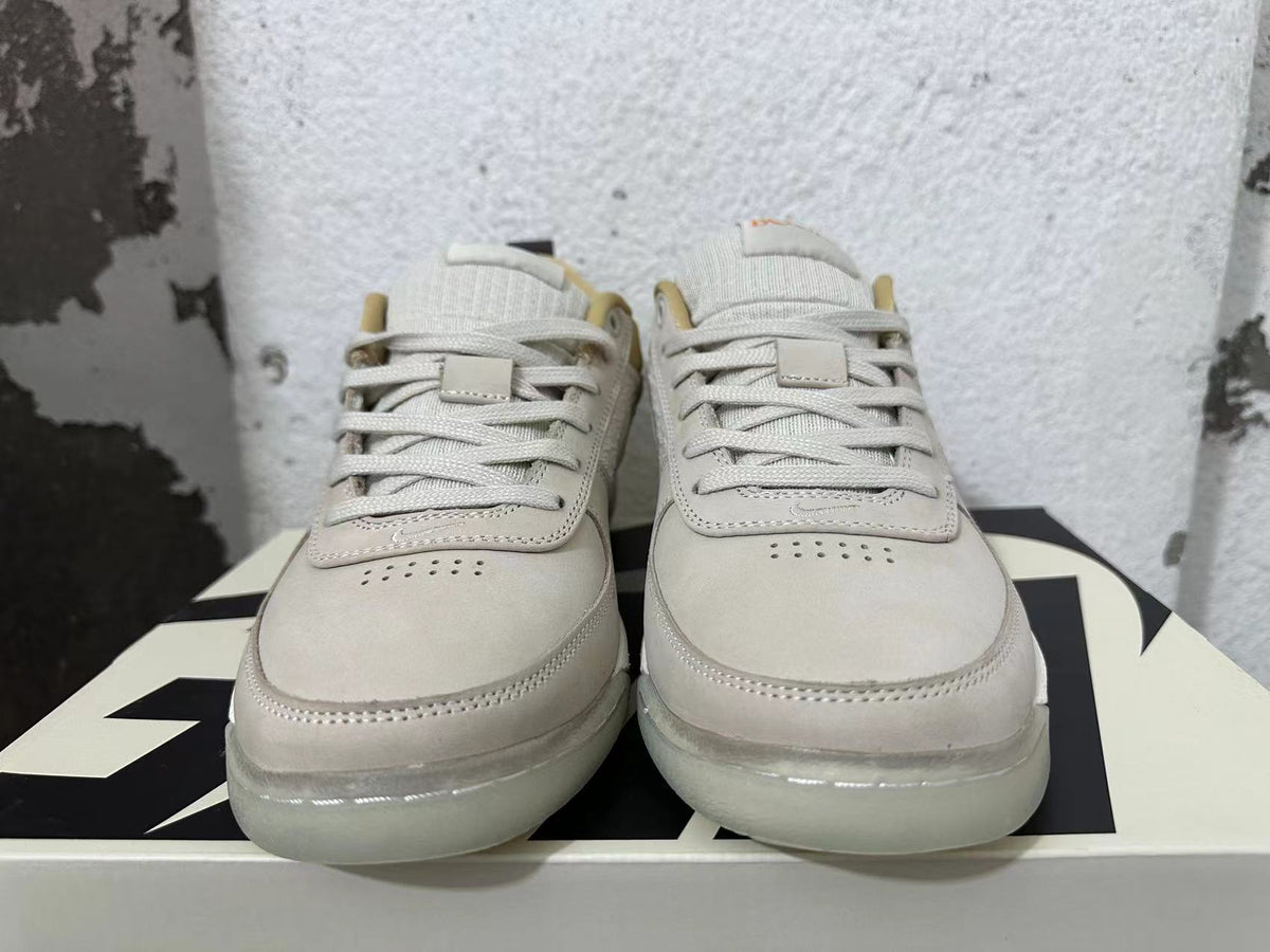 Front view of cream and light grey Nike Book 1 sneakers with lace-up closure