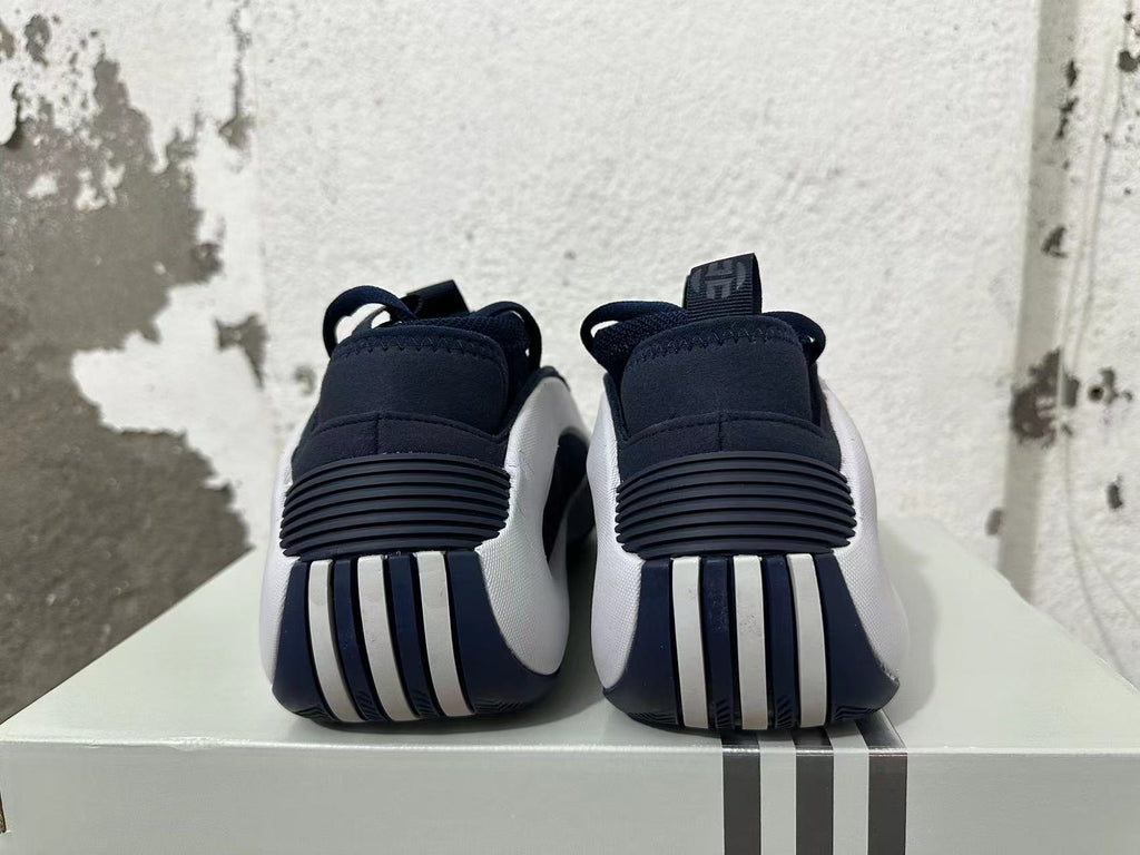 Rear view of navy and white Adidas basketball shoes showing ribbed heel details.