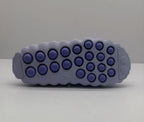 Outsole view showing the purple circular traction elements and textured perimeter.