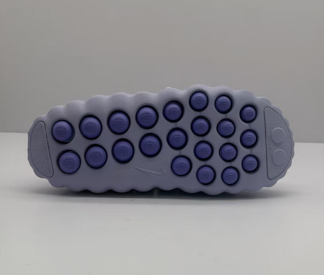 Outsole view showing the purple circular traction elements and textured perimeter.