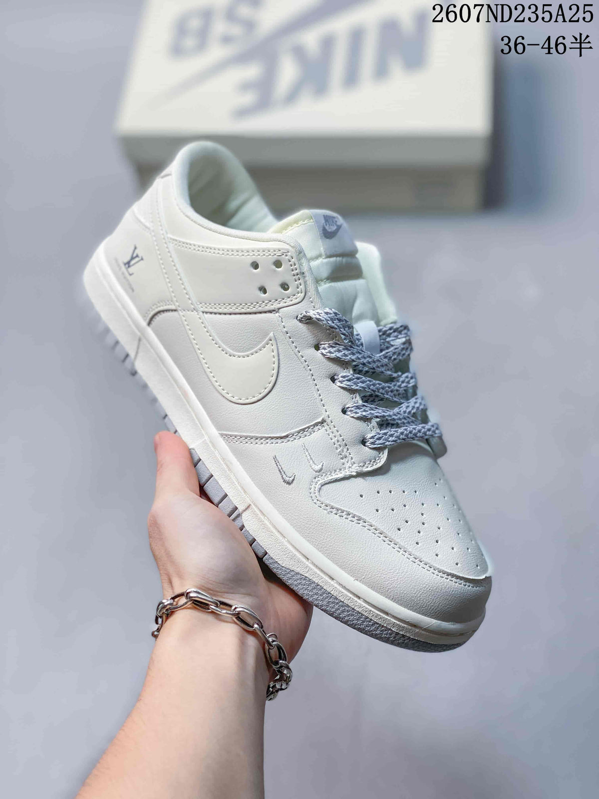 Handheld side view of a white sneaker with tonal Swoosh-style detailing, grey laces and Louis Vuitton branding.