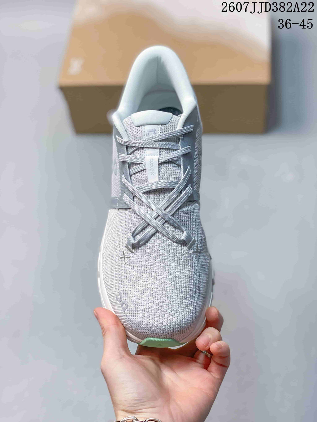 Top view of the lace-up sneaker showing the gray textured upper, tongue label and mint-colored toe accent.
