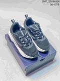 Pair of black and white Dior low-top sneakers displayed on a shoe box, showing the rounded toe, layered upper, and thick sole.