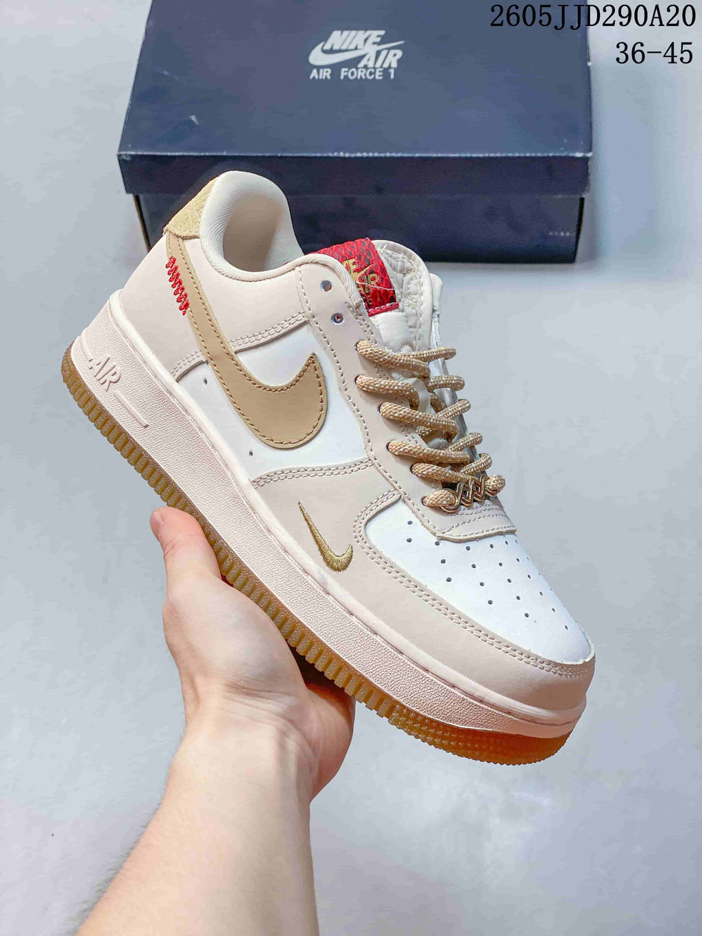 Close-up of a white Nike Air Force 1-style sneaker with beige Swoosh, tan laces and a gum-colored outsole.