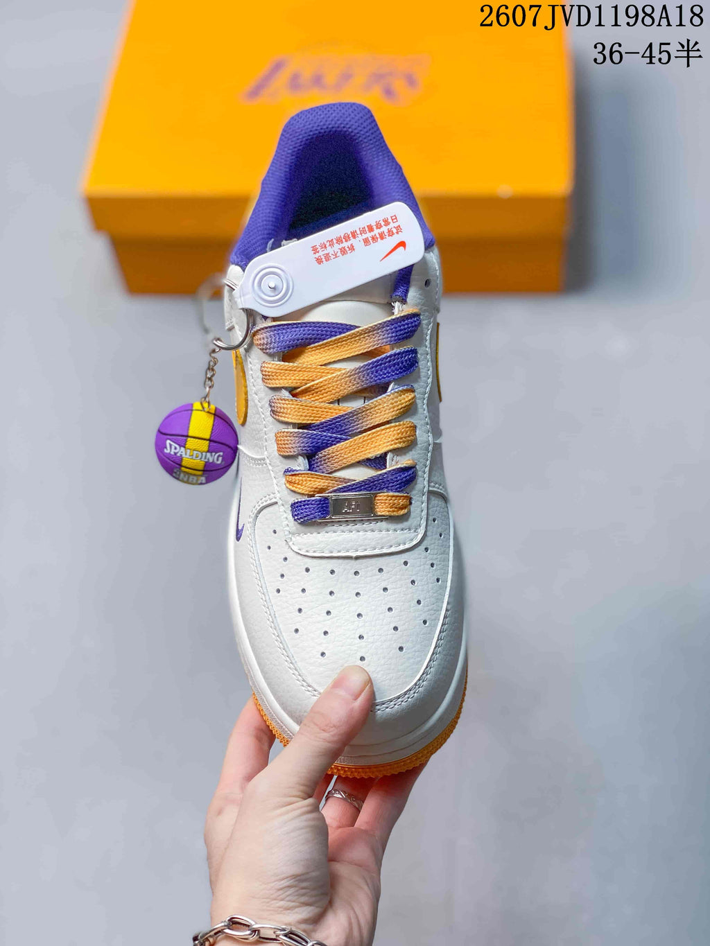Top view showing the perforated toe box, purple and gold laces, and basketball-themed accessory.