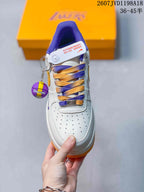 Top view showing the perforated toe box, purple and gold laces, and basketball-themed accessory.