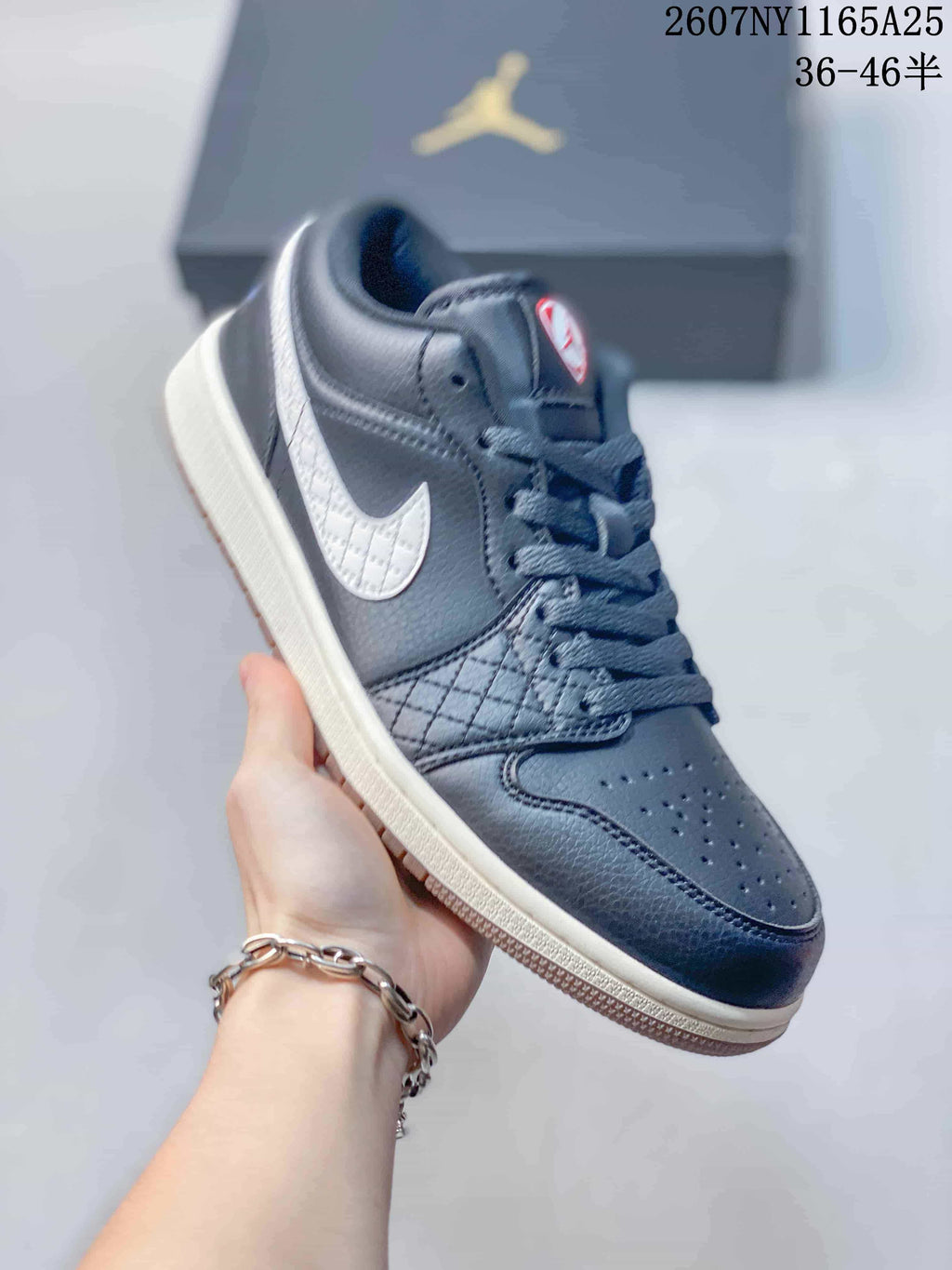 Angled side view of the black low-top sneaker with white Swoosh and light midsole