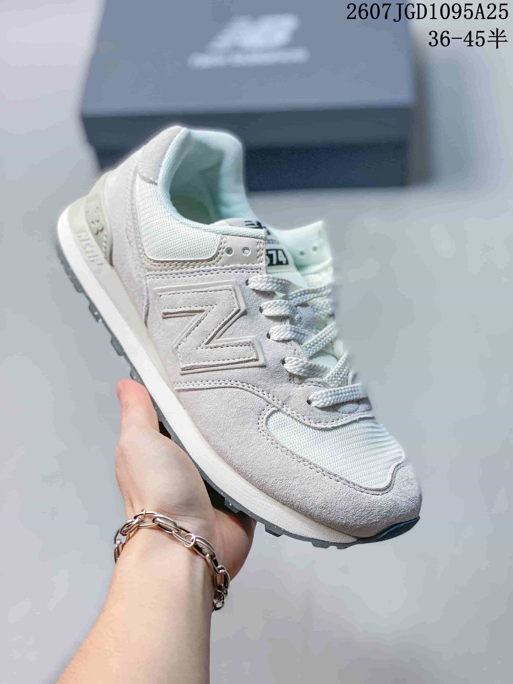 Angled side view of the white and grey New Balance 574 sneaker with the signature side logo and lace-up construction.