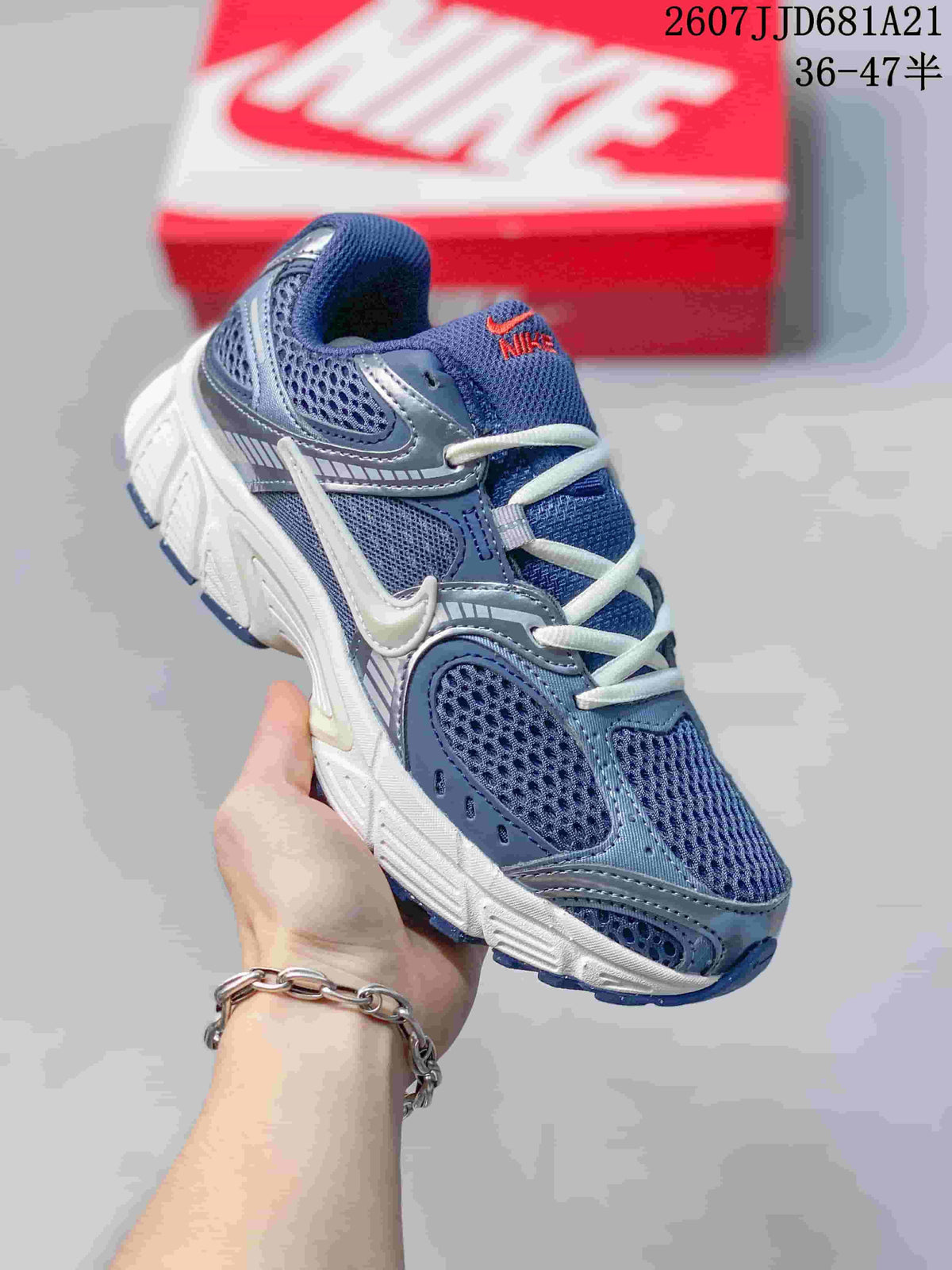 Angled front-side view of a blue and white Nike V5 RNR sneaker showing the layered upper, laces and chunky midsole.