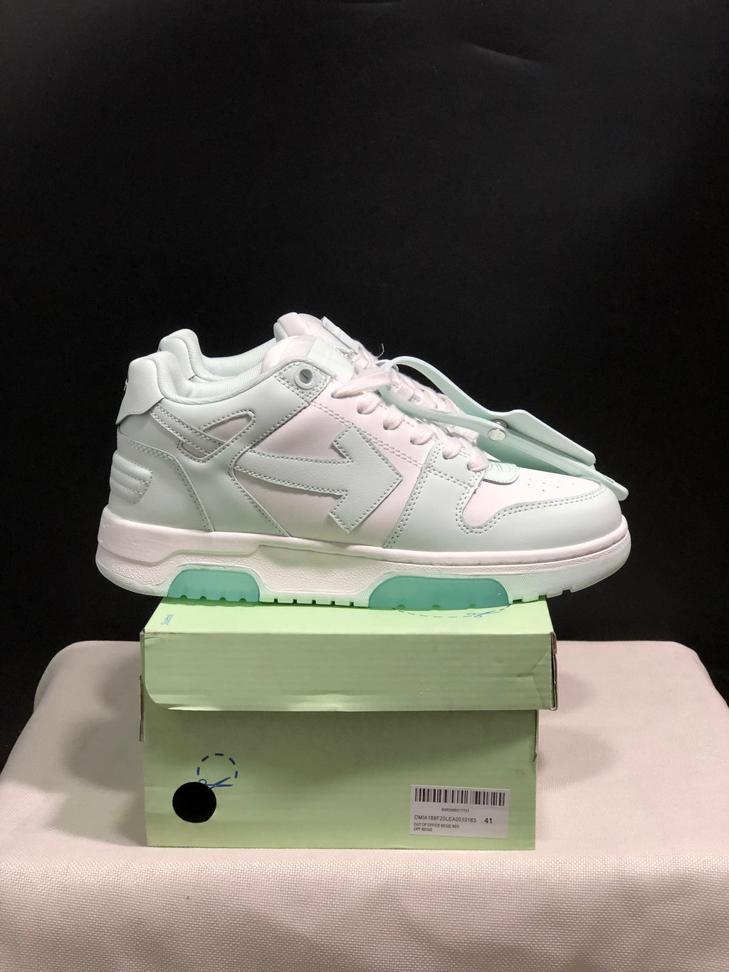 Side view of a white low-top sneaker with layered panels, large side detailing, padded collar and pale mint outsole sections.