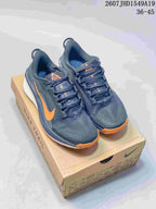 Pair of dark gray and orange Nike Zoom Fly 5 sneakers displayed on a shoebox.