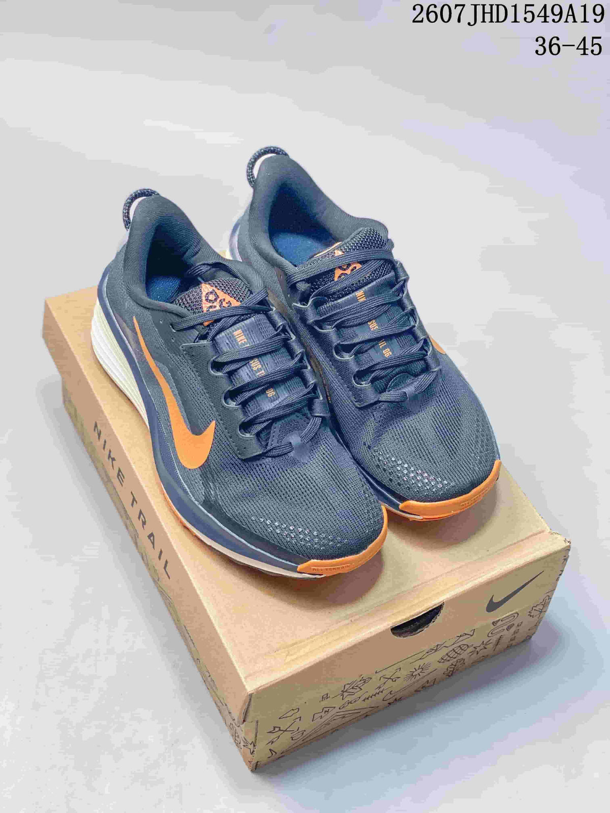 Pair of dark gray and orange Nike Zoom Fly 5 sneakers displayed on a shoebox.