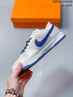 Side view showing the white upper, blue side detailing, white midsole, and blue outsole.