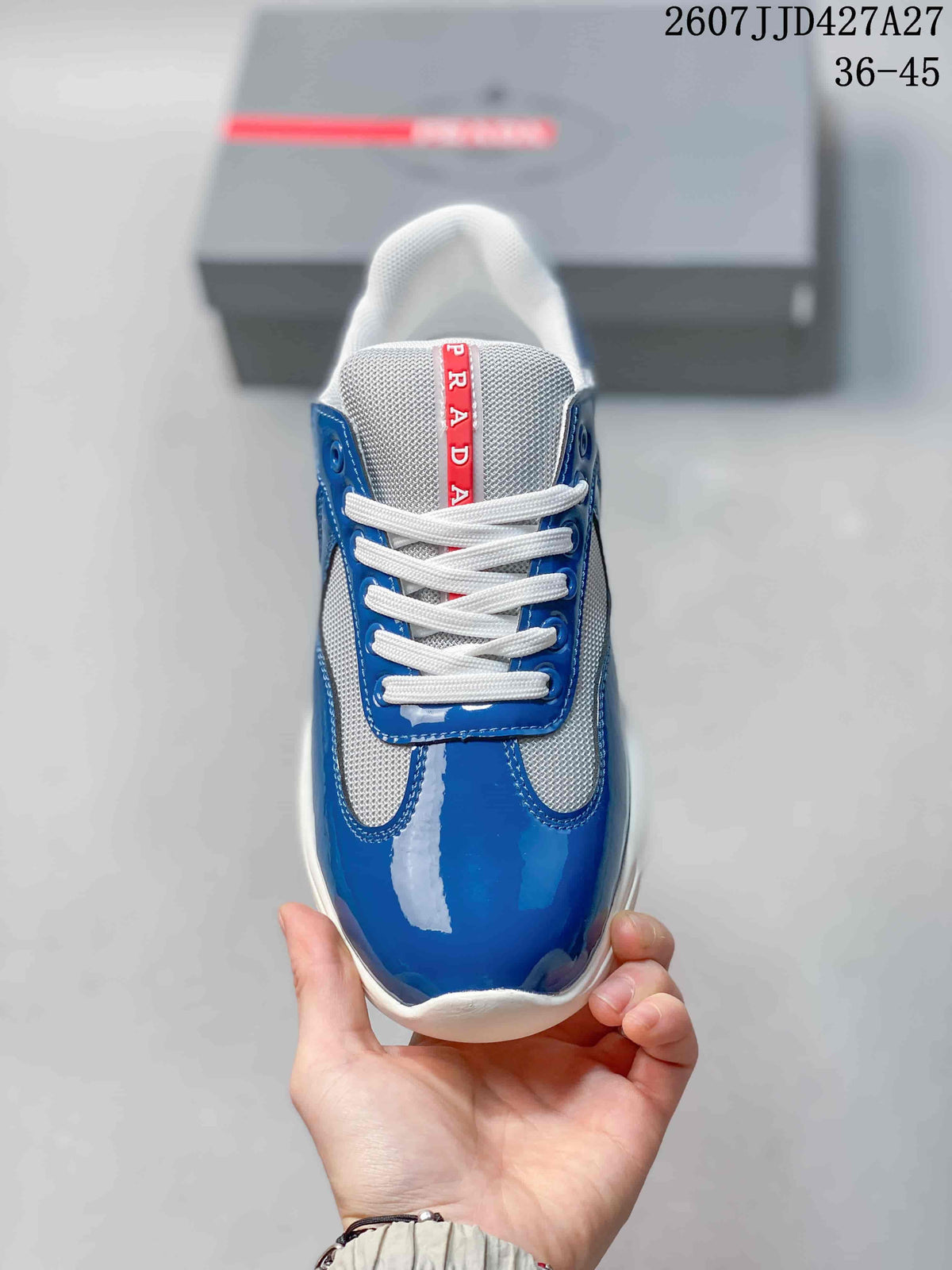 Top view of the blue and white lace-up sneaker with red Prada tongue detailing.