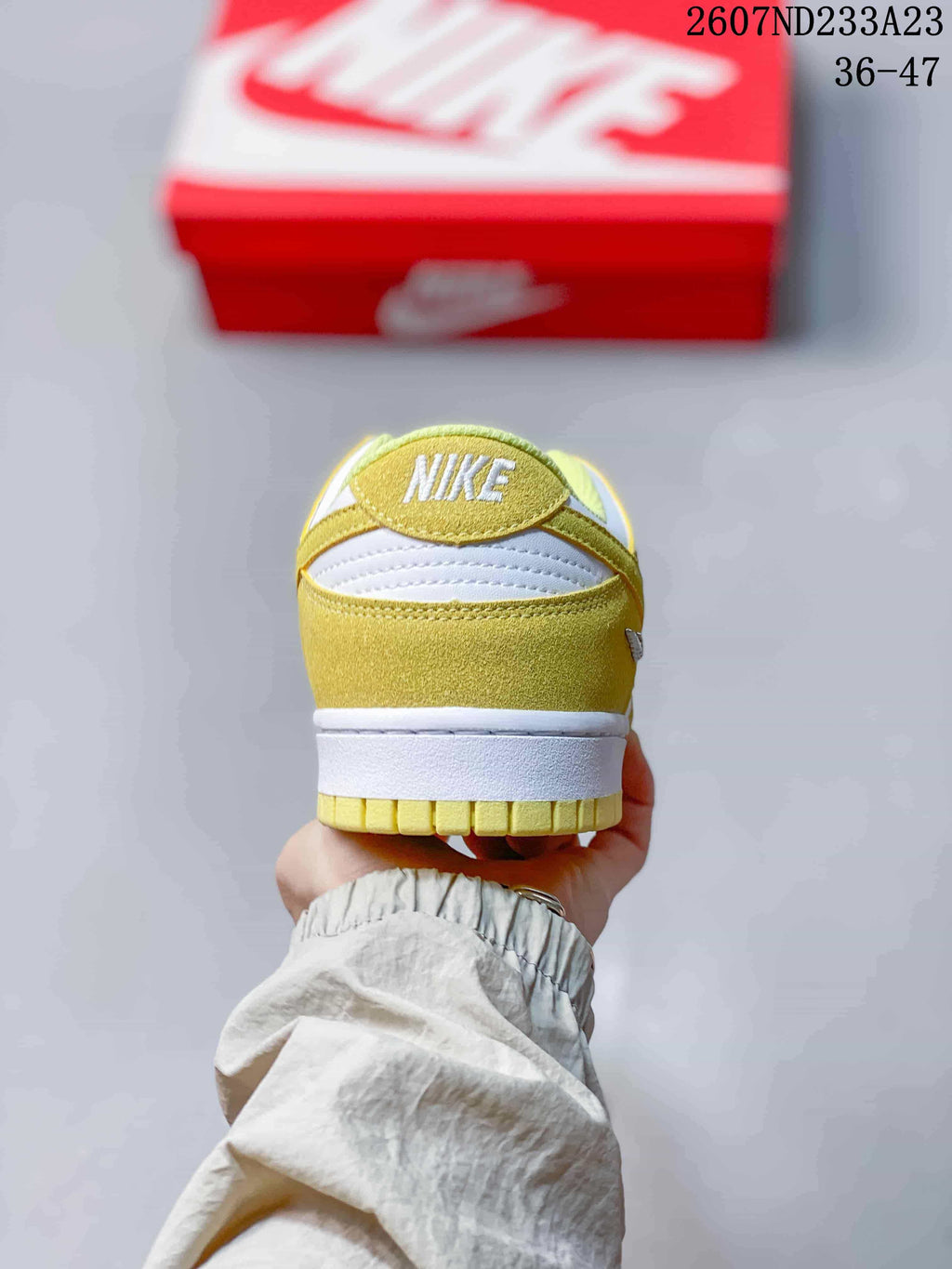 Rear view of the sneaker showing the yellow heel panel, white midsole, and Nike branding.