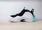 Side profile of a white Nike Air Foamposite One sneaker with black collar and turquoise tag