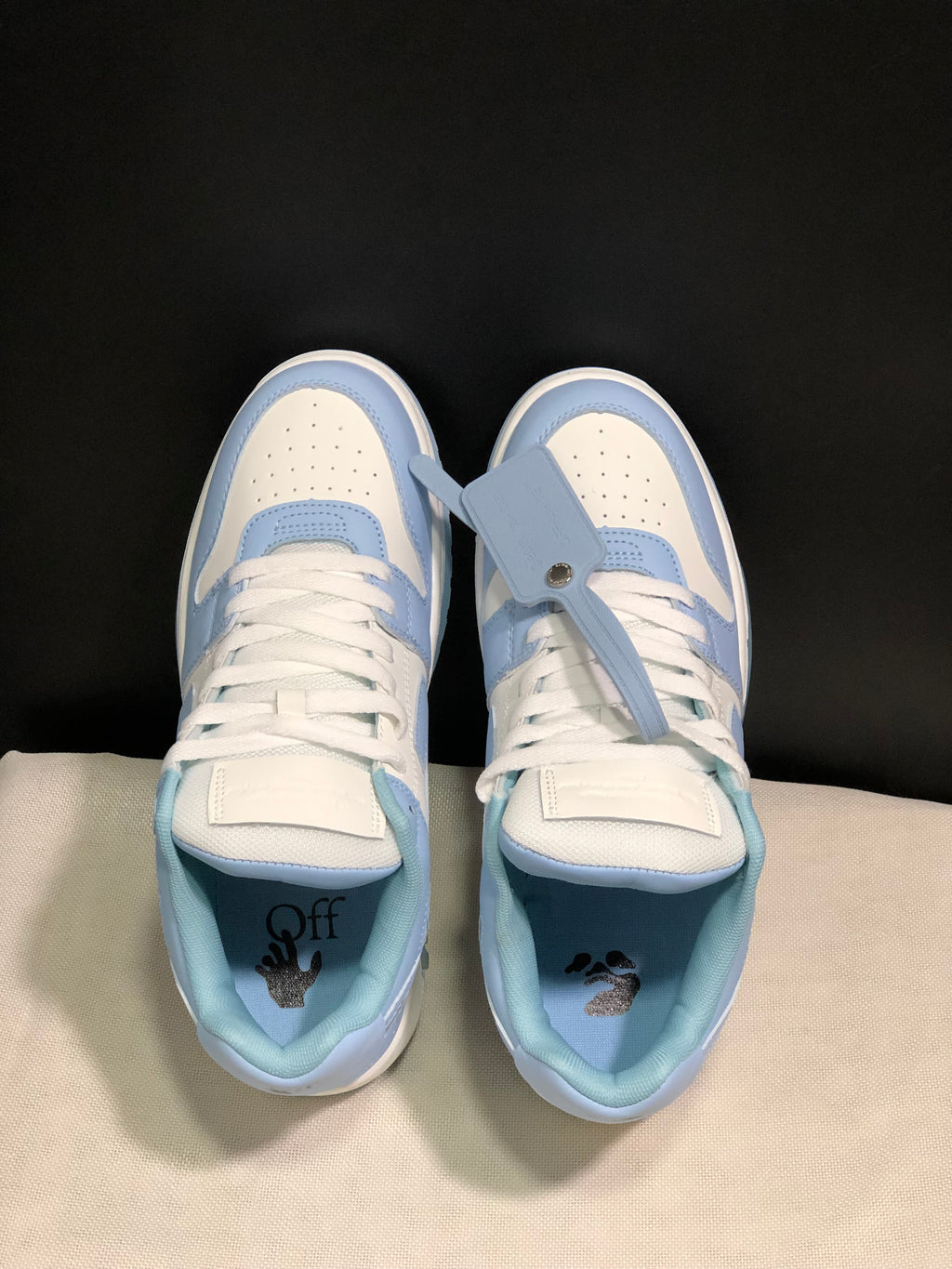 Top view showing the perforated toe boxes, white laces, blue overlays, and interior graphics.