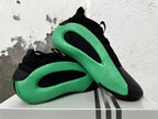 Pair of black and green Adidas basketball shoes shown from the side.
