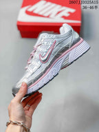 Side profile of the silver and pink sneaker showing layered panels, lace-up construction, Nike Swoosh branding, and a textured outsole.