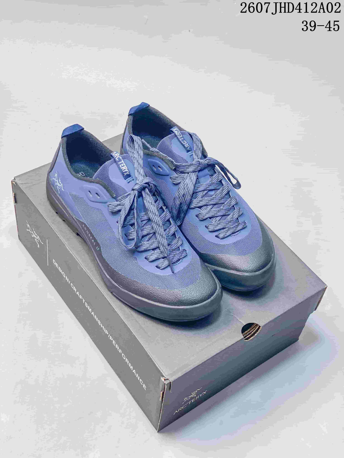 Pair of blue and dark gray Arc'teryx Konseal LT shoes displayed on a shoe box