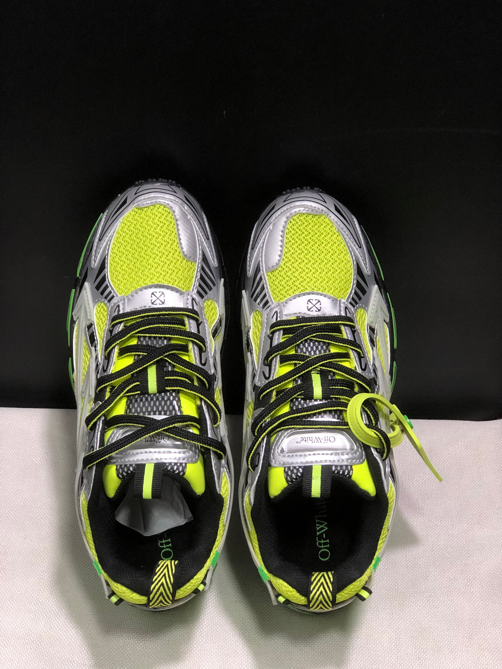 Top-down view showing the neon mesh-like uppers, black-and-neon laces, silver overlays, and tongue detailing.