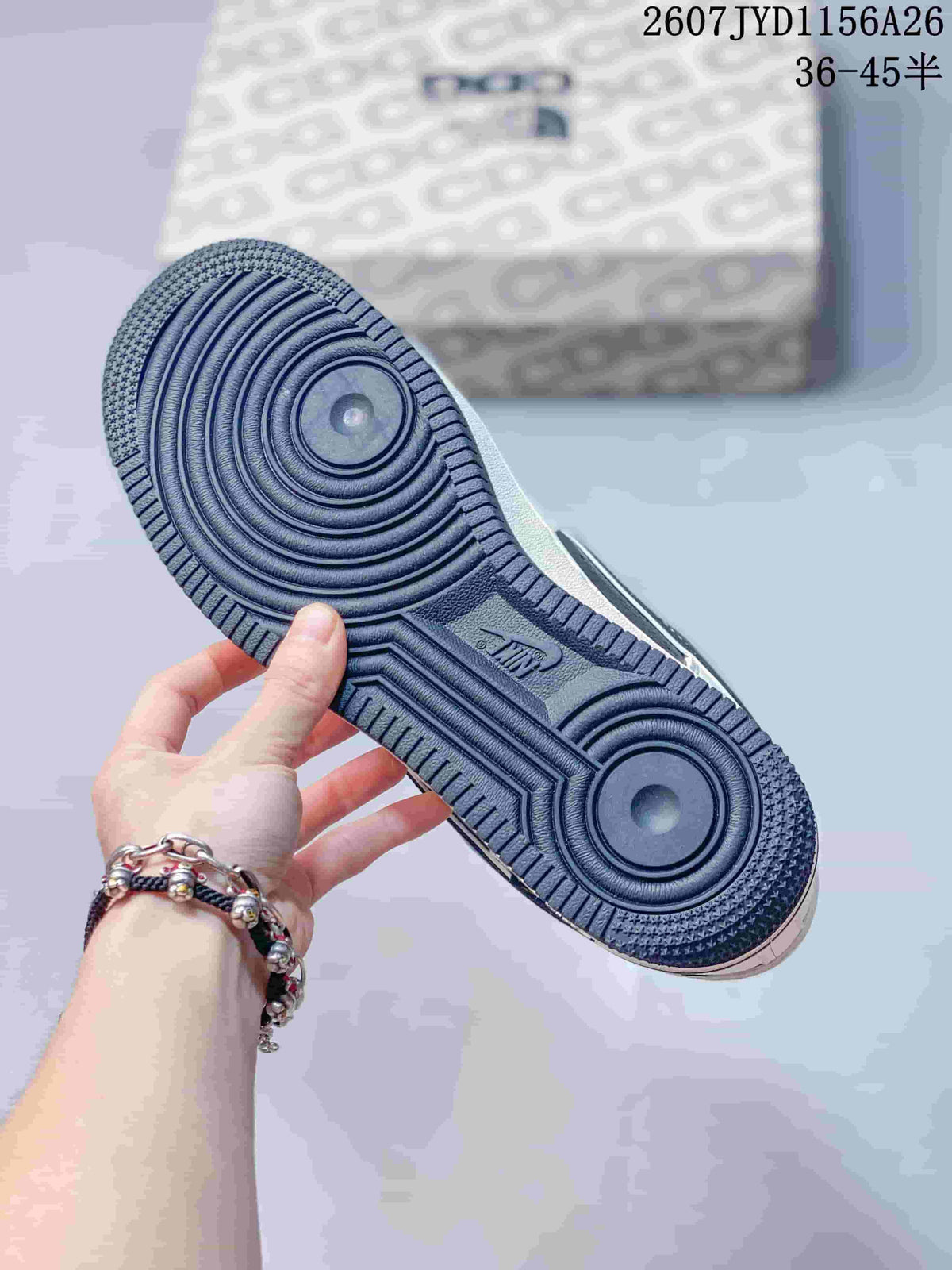Close view of the dark textured rubber outsole with circular traction sections on a Nike Air Force 1 sneaker.