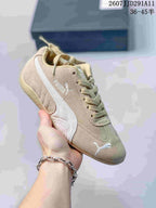 Beige PUMA sneaker with a white side stripe, tonal laces, and a gum-colored outsole.