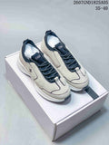 Pair of off-white and dark Chanel sneakers displayed on a white shoebox.