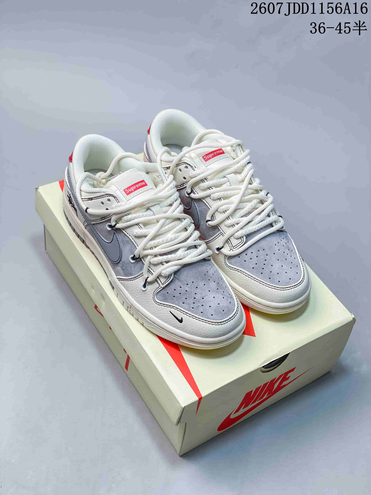 Pair of off-white and grey low-top sneakers with red tongue labels and contrasting grey toe panels, photographed on a shoe box.