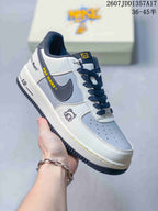 Angled side view showing the white and gray upper, dark Swoosh, decorative graphics, and yellow accent lettering.