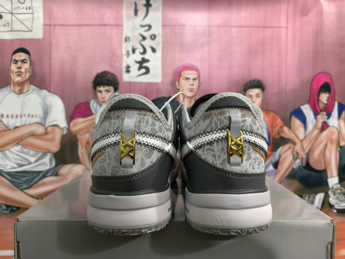 Rear view of silver and gray Nike basketball shoes with patterned uppers and gold-tone heel details
