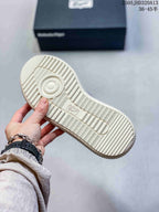 Underside of the sneaker showing a ribbed off-white outsole