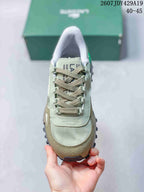 Top view of the sneaker showing the rounded toe, woven-style laces, stitched panels, and tongue branding.