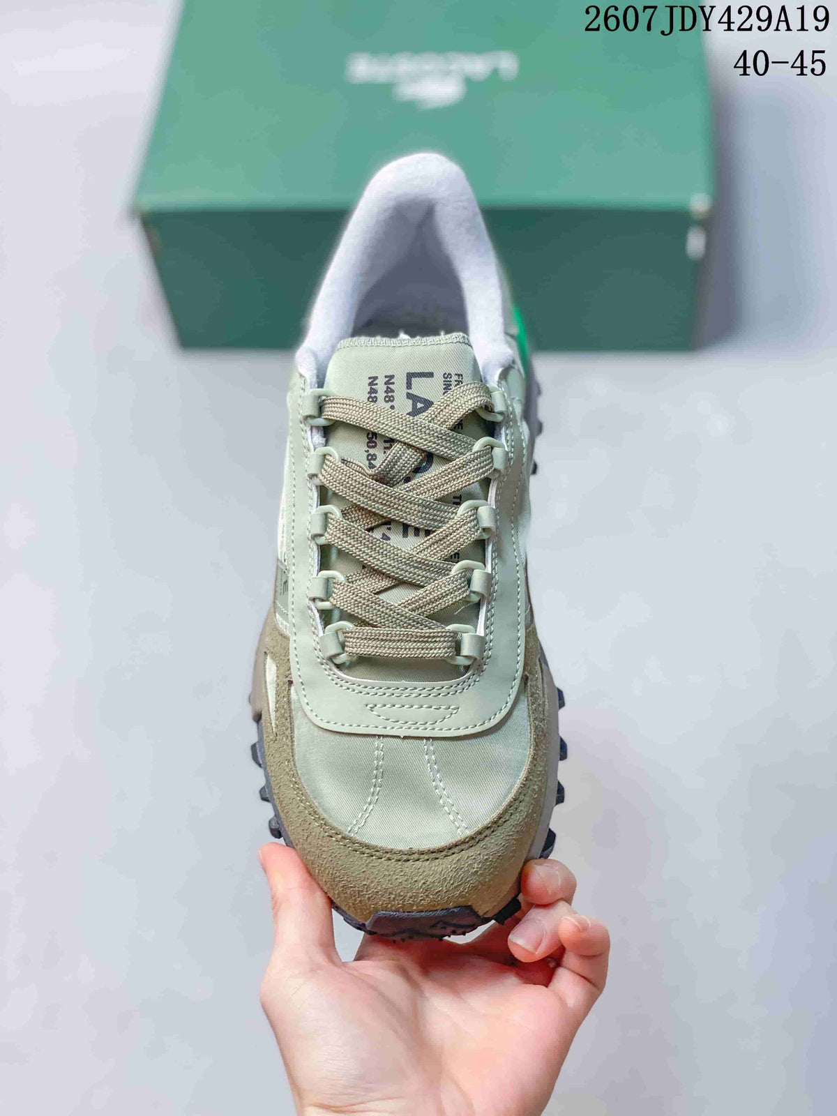 Top view of the sneaker showing the rounded toe, woven-style laces, stitched panels, and tongue branding.
