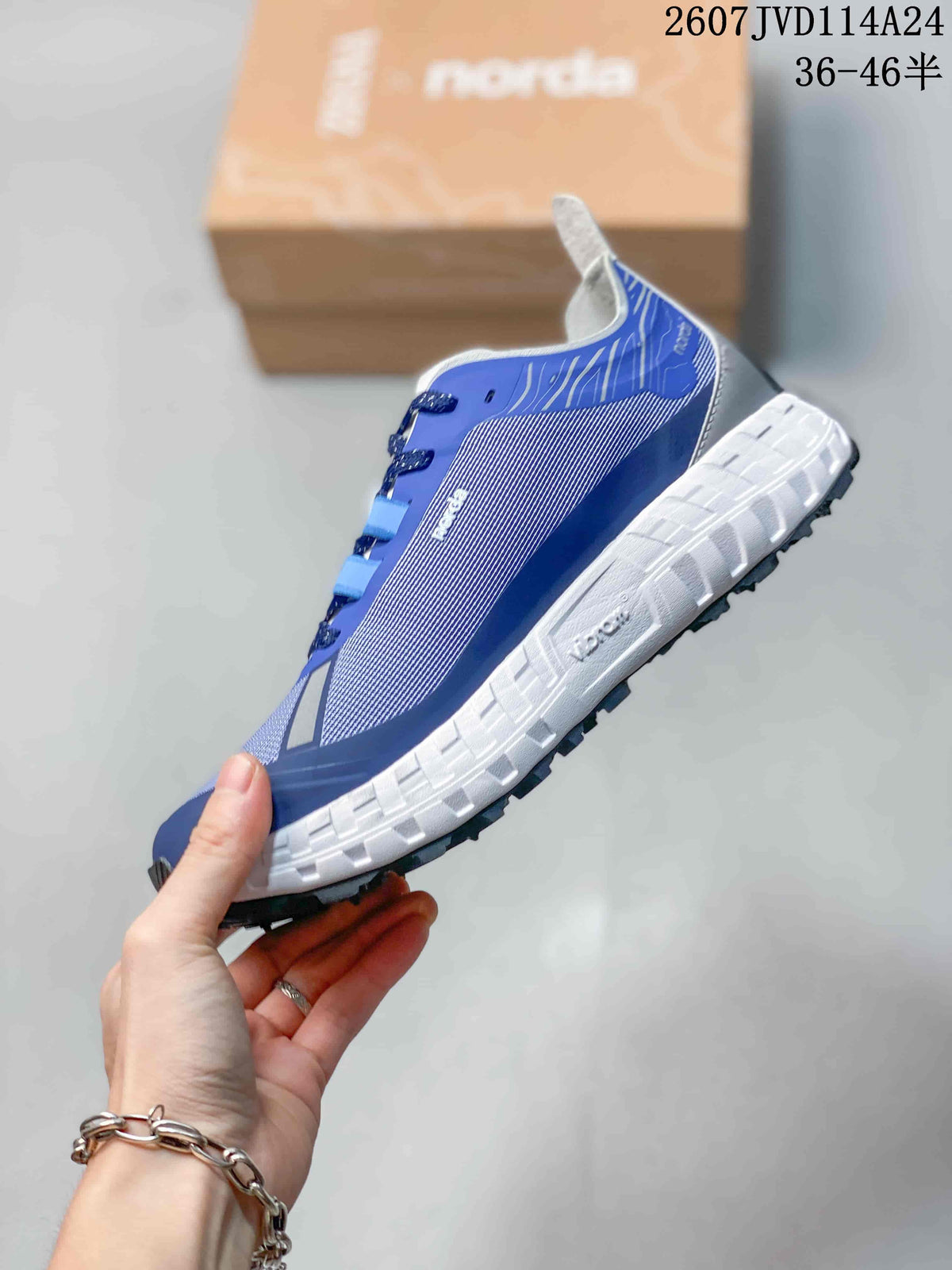 Side profile of the blue and gray NORDA sneaker showing the layered upper, white segmented midsole, and black outsole.