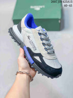 Angled side view of the Lacoste sneaker showing the white and black upper, blue accents, and textured outsole.