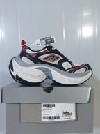 Skechers 1101 sneaker displayed on its box; the label shows model text, BLACK/ORANGE color information and a photographed size of C 39.