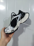 Black-and-white mesh sneaker shown from the outer side in hand.