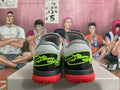 Rear view of grey and black Nike basketball shoes with lime green details and coral outsoles