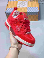 Close-up of a red Trainer-style sneaker showing layered panels, mesh sections, and side emblem.
