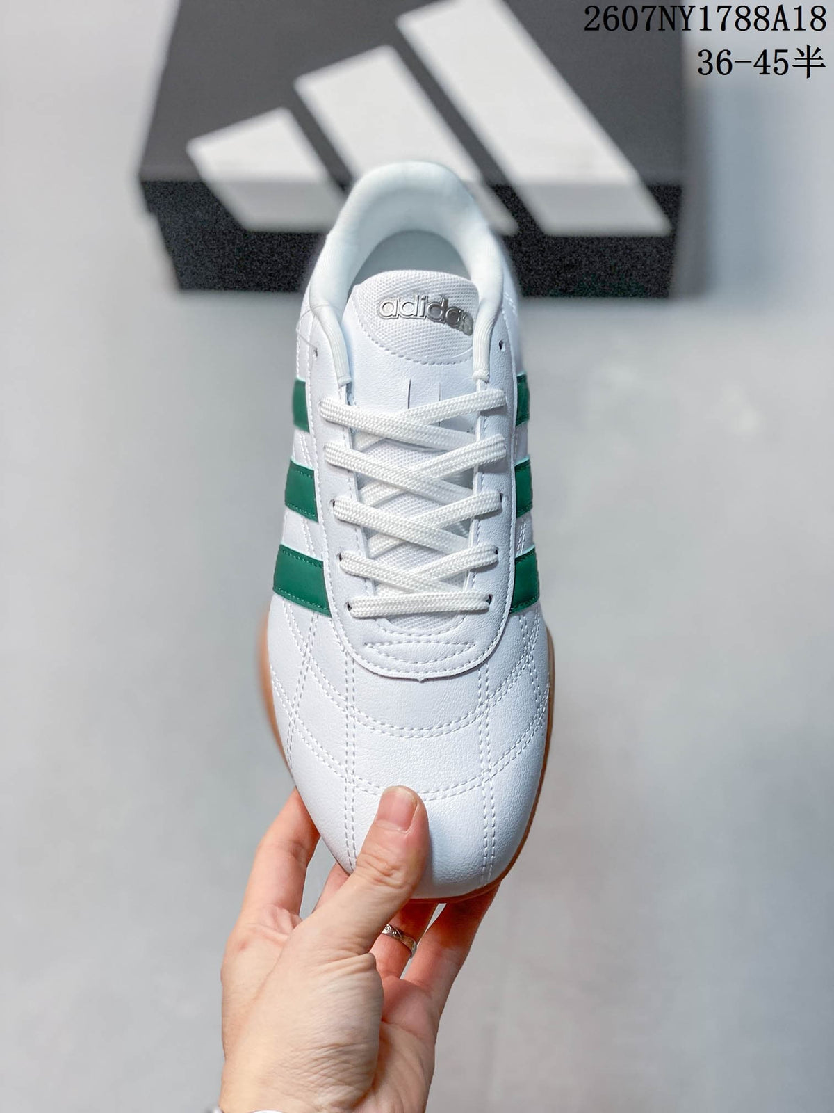 Top view of the white adidas trainer showing white laces, stitched panels and green side stripes