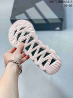 Close view of the patterned outsole showing sculpted channels and multiple open cutout sections.