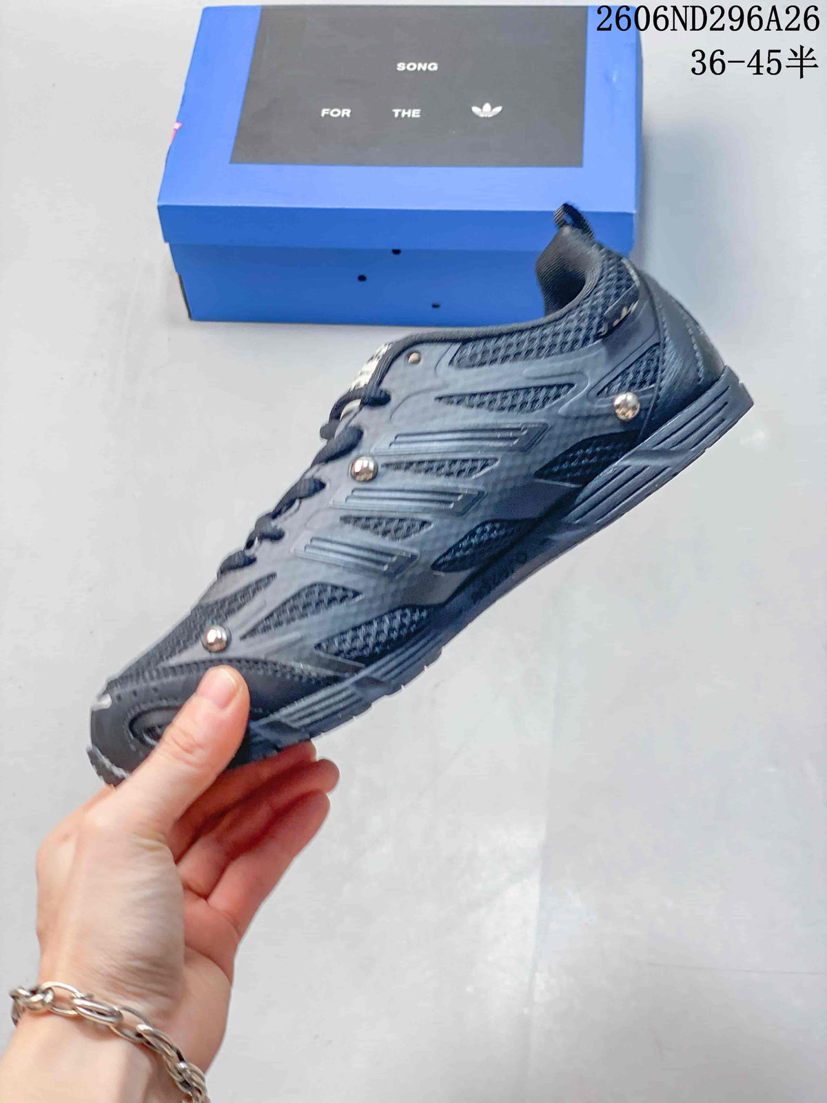 Side profile showing the low-top silhouette, layered panels, silver accents, and lace-up construction.
